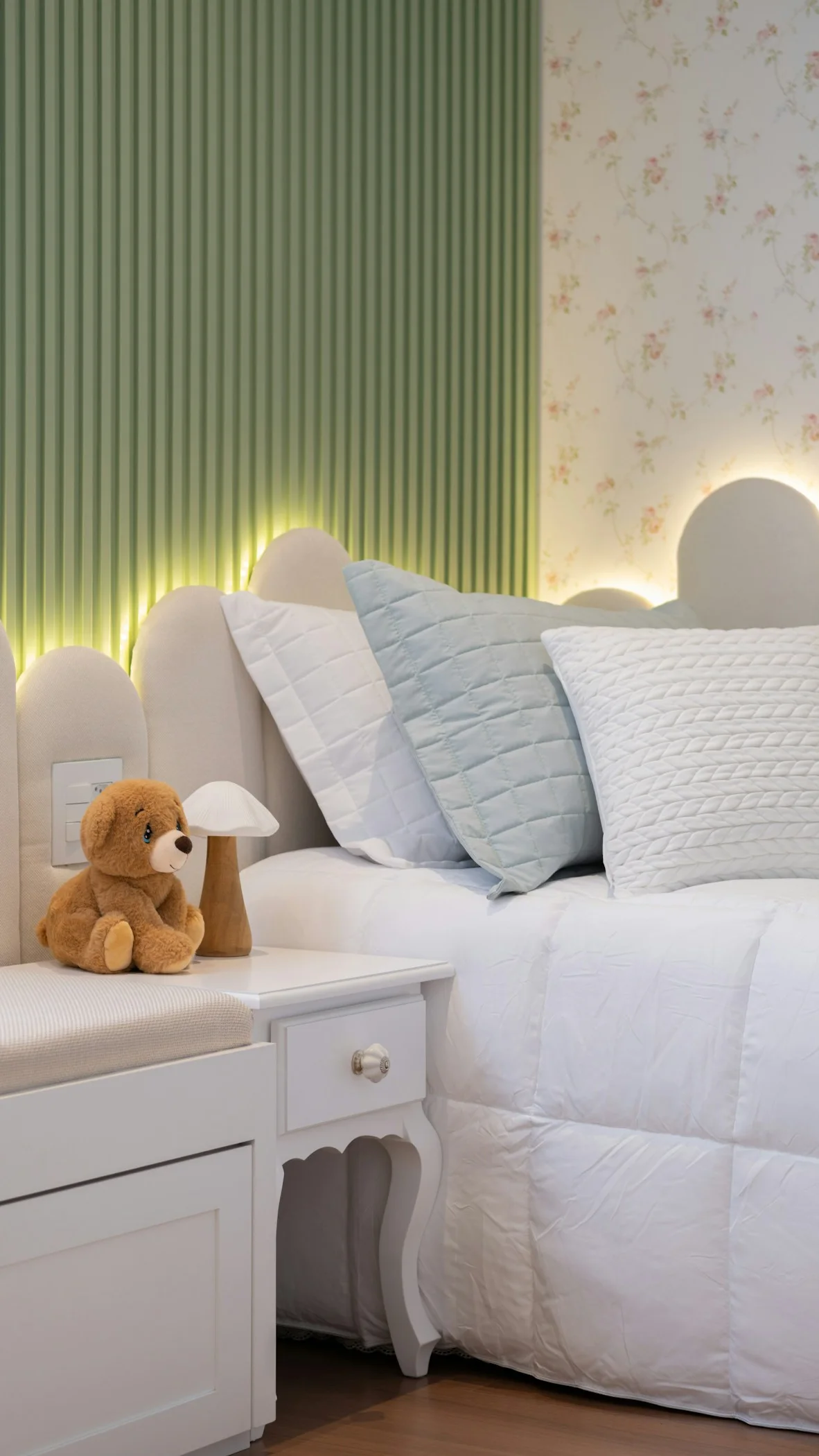 Habitación infantil con cama, cojines y mesa de noche, antes de decorar con arte