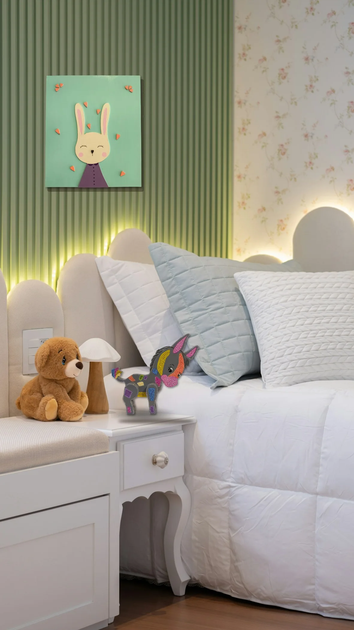 La misma habitación infantil con el Burro pintado a mano en la mesa de noche y un cuadro de conejito de Esperanza Arcila en la pared